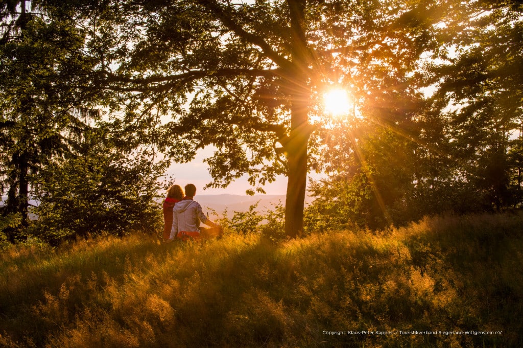 An der "schönen Aussicht" oberhalb von Sohlbach sitzen zwei Frauen auf einem Baumstamm und schauen in den Sonnenuntergang hinein.